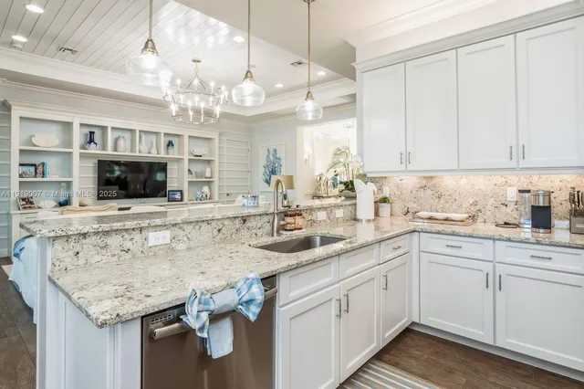 a kitchen with stainless steel appliances granite countertop a sink and dishwasher with white cabinets