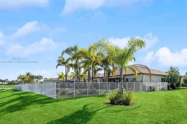 a green field with some trees in front of it