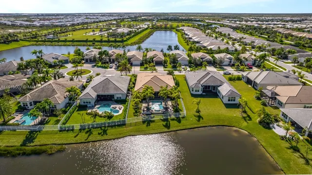 an aerial view of a house with a swimming pool yard and lake view