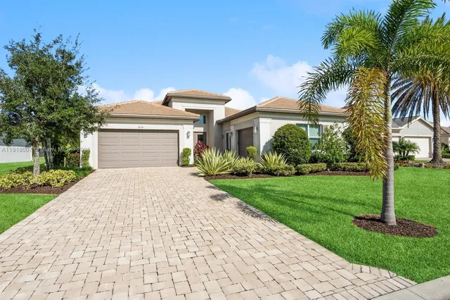 a front view of a house with a yard and potted plants