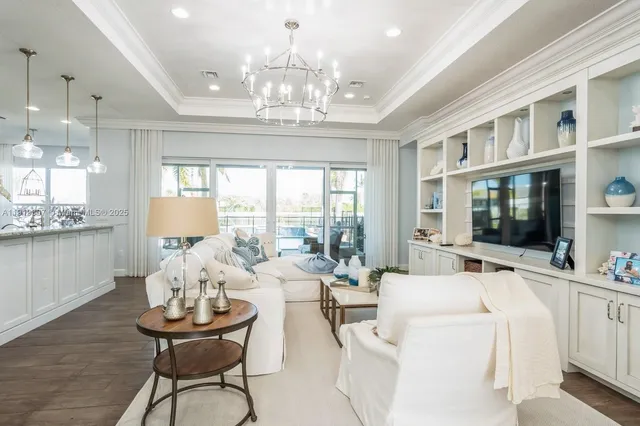 a living room with furniture a chandelier and a flat screen tv