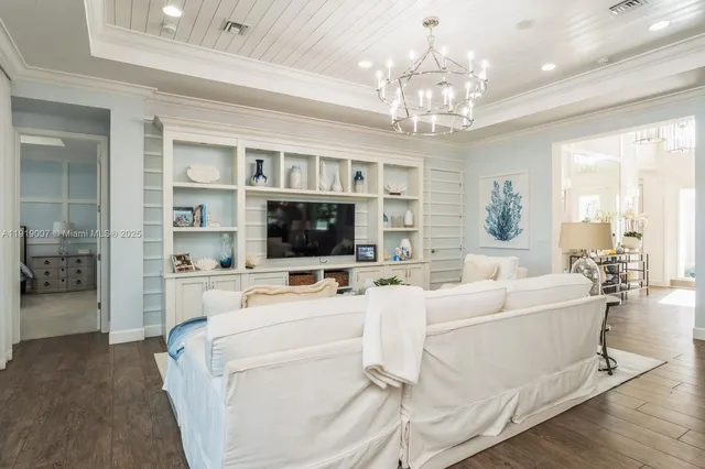 a living room with furniture a chandelier and a flat screen tv