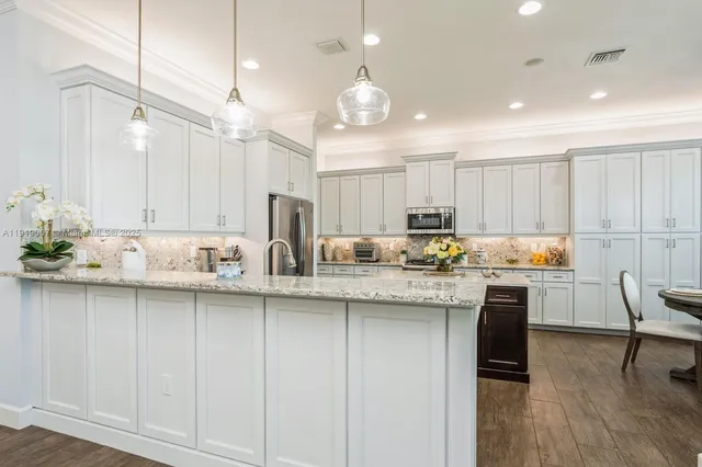 a kitchen with center island white cabinets and stainless steel appliances