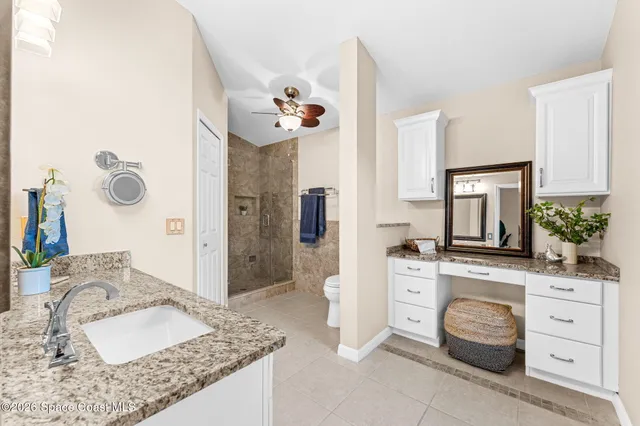 a bathroom with a granite countertop sink a mirror and shower