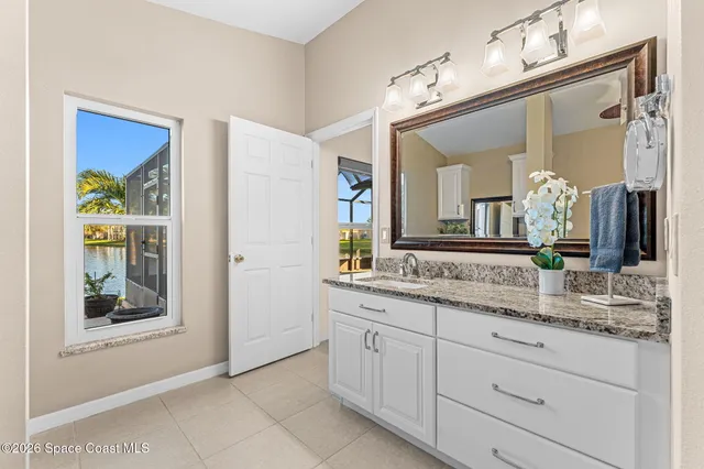 a bathroom with a granite countertop sink vanity and mirror