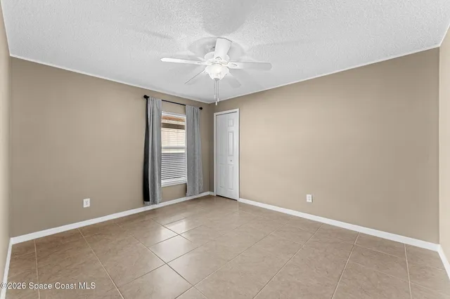 an empty room with windows and fan