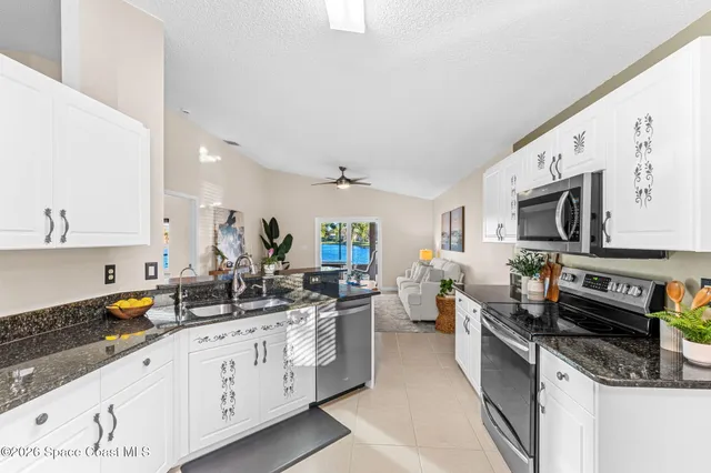 a kitchen with stainless steel appliances sink stove microwave and cabinets