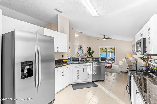 a kitchen with stainless steel appliances kitchen island granite countertop a refrigerator and a stove