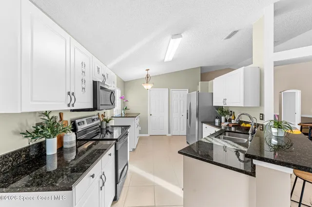 a kitchen with stainless steel appliances granite countertop a sink a stove and a refrigerator