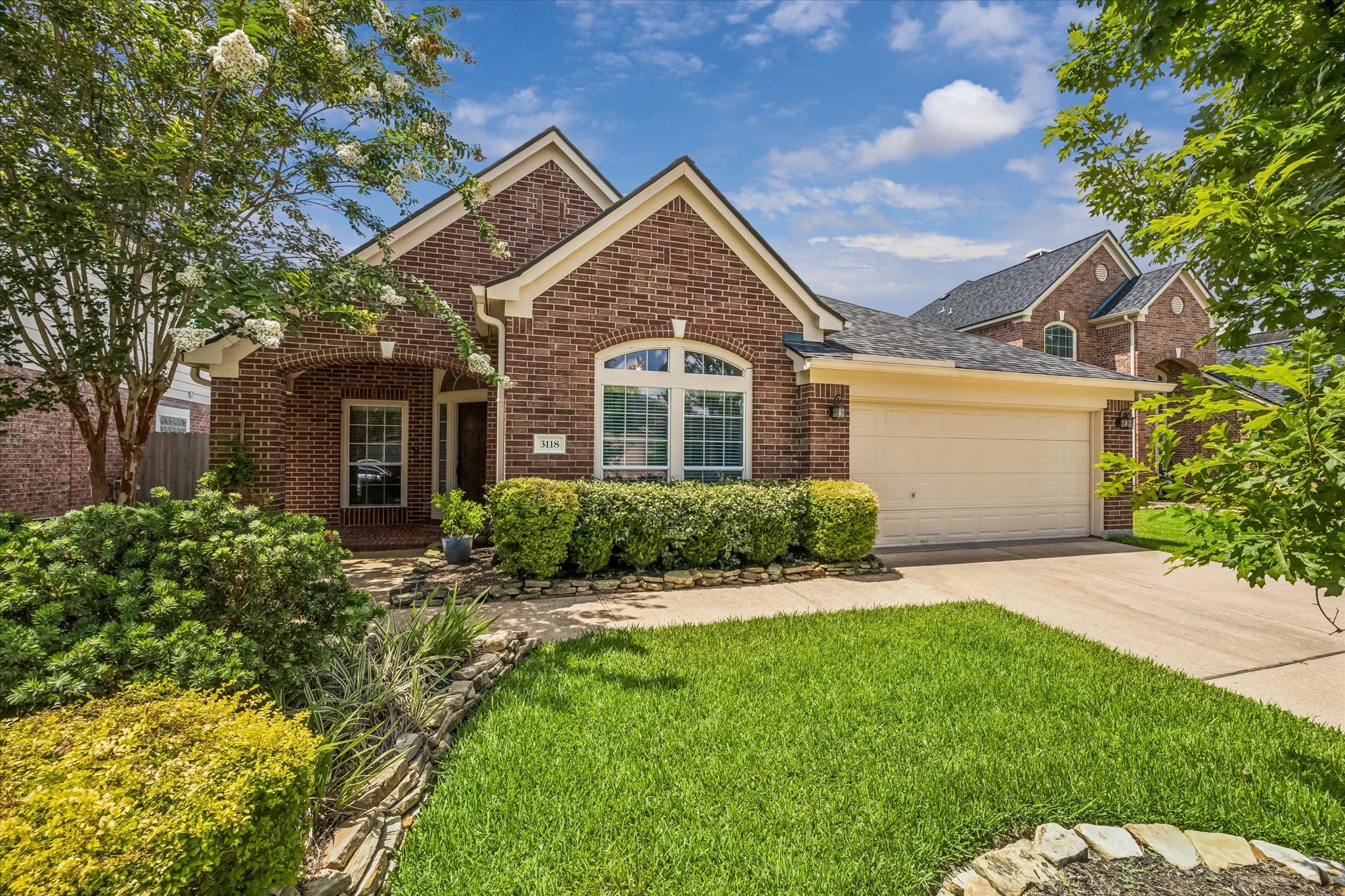 3118 Valley Court Manvel, TX 77578 - Photo 21 of 38 This charming brick home features a well-maintained lawn, manicured shrubs, and a two-car garage. Its inviting entryway is accented by a cozy porch, perfect for relaxing outdoors.
