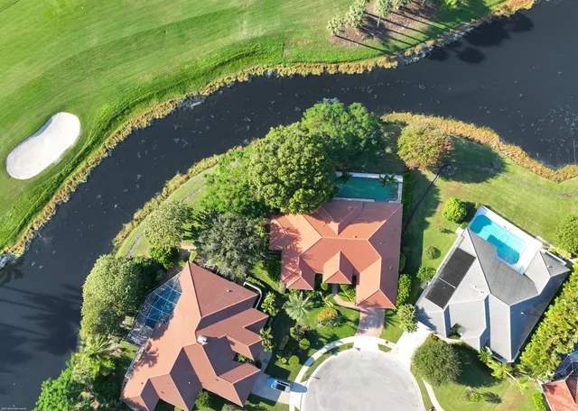 an aerial view of a house with a garden and lake view