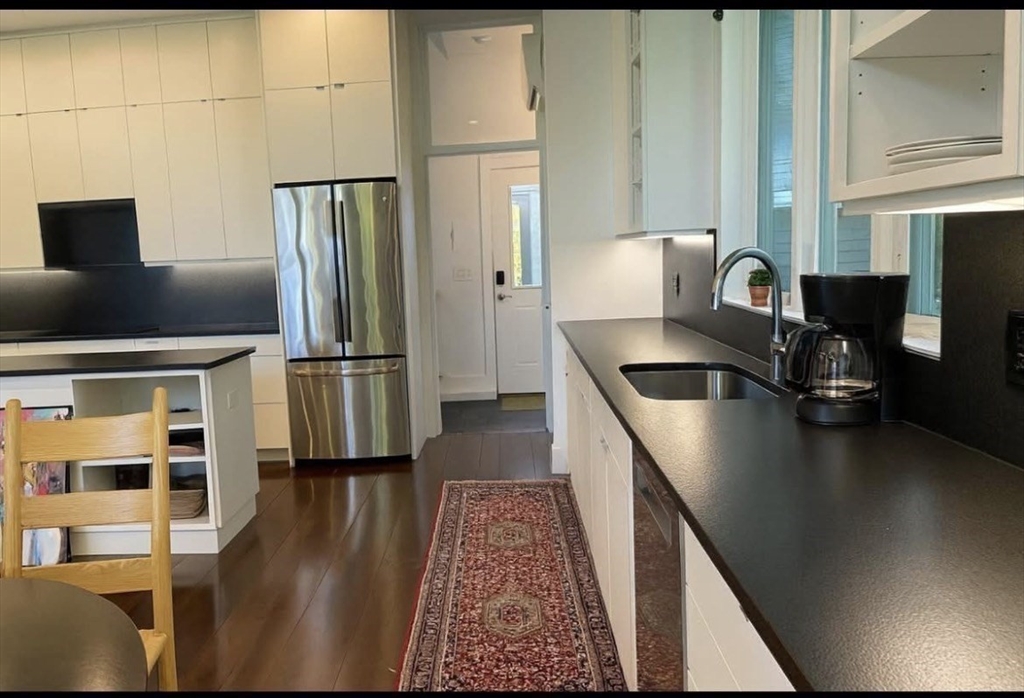 25 Sturges Road, Unit 1 Sharon, MA 02067 - Photo 6 of 11 a kitchen with stainless steel appliances granite countertop a refrigerator a stove and white cabinets with wooden floor