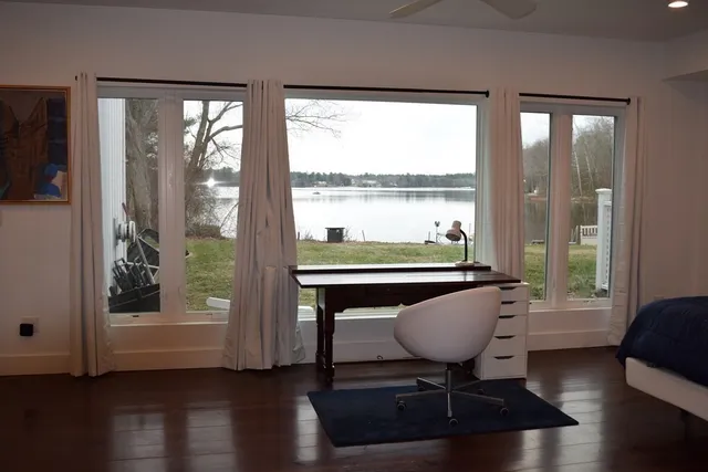 a view of a room with wooden floor and furniture