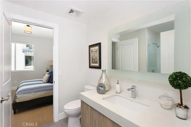 a bedroom with a large bed and a potted plant