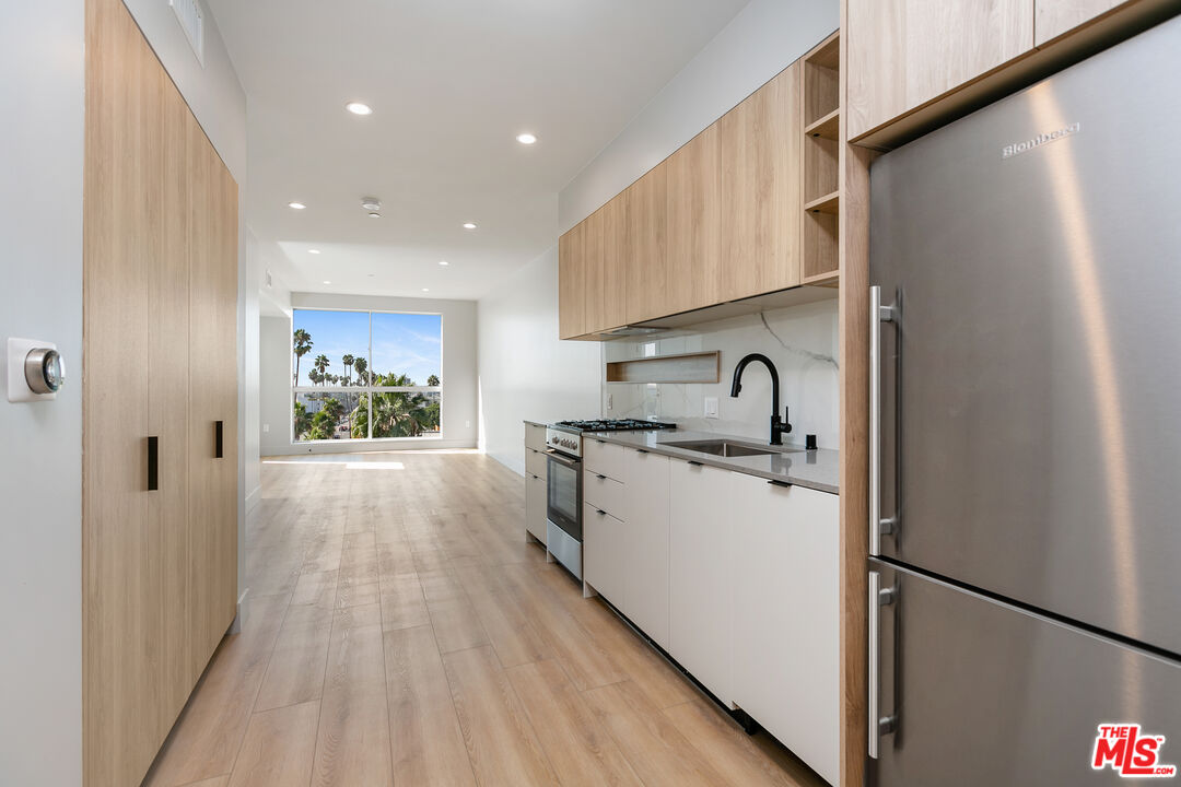 12431 Rochester Avenue, Unit PH4 Los Angeles, CA 90025 - Photo 2 of 28 a kitchen with a sink a refrigerator and cabinets