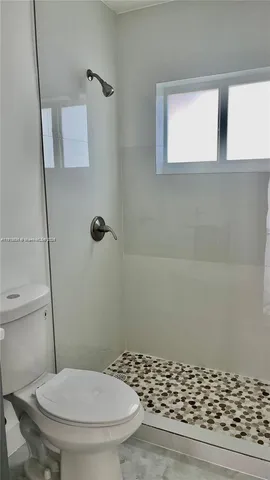 a bathroom with a toilet and a shower