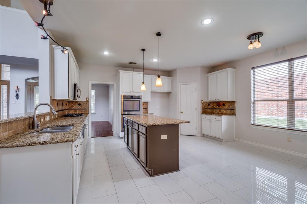 3421 Neiman Road Plano, TX 75025 - Photo 12 of 40 Kitchen with appliances with stainless steel finishes, tasteful backsplash, light stone countertops, recessed lighting, and a kitchen island