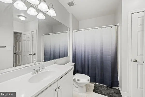 a bathroom with a sink vanity mirror and toilet