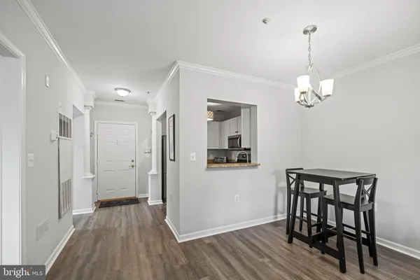a view of a room with wooden floor and a chandelier