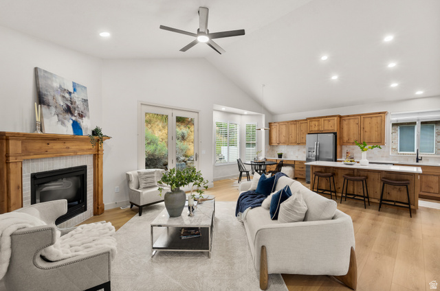 Vaulted ceilings, wood-finish flooring, fireplace with wood mantel, built-in kitchen cabinetry, and French doors