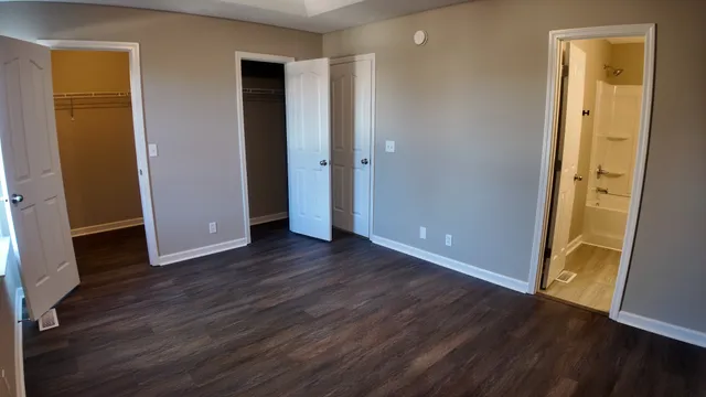 an empty room with wooden floor and closet