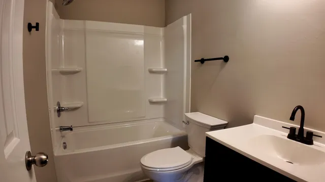 a bathroom with a sink a toilet and shower