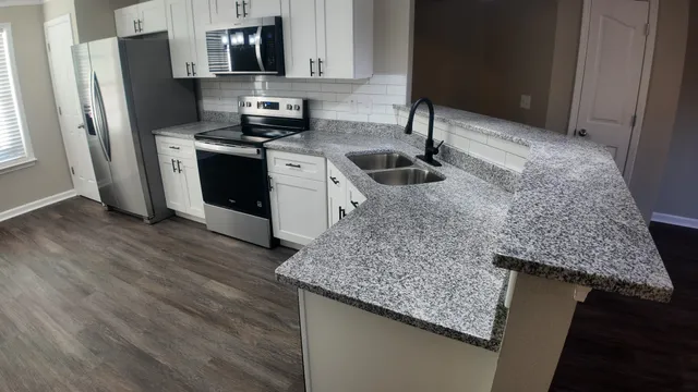 a kitchen with stainless steel appliances granite countertop a sink stove and refrigerator