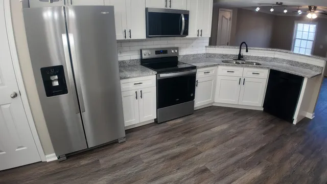 a kitchen with stainless steel appliances granite countertop a sink stove and refrigerator