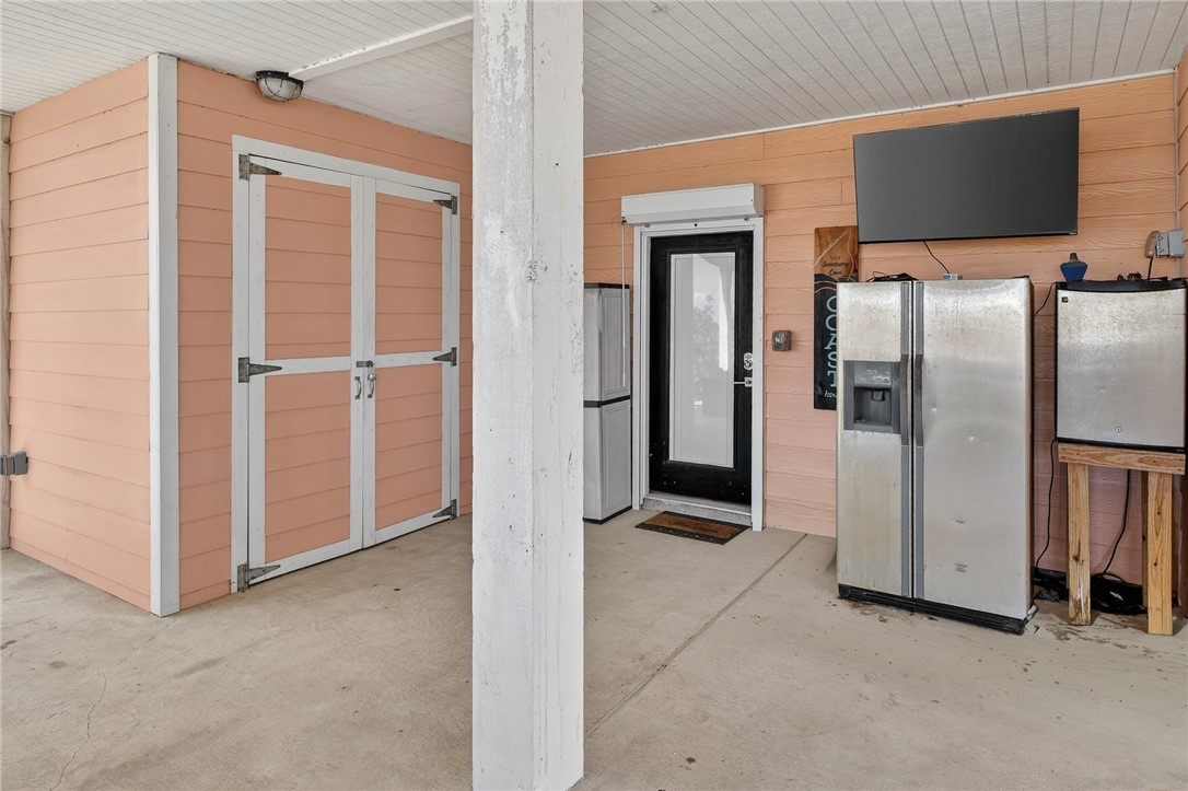 838 Rattlesnake Point Road Rockport, TX 78382 - Photo 26 of 40 an empty room with wooden floor kitchen view and windows