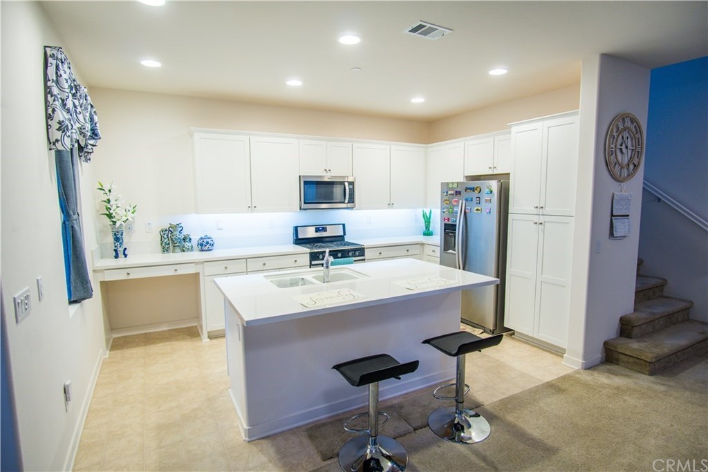 8865 Maple Avenue Montclair, CA 91763 - Photo 3 of 26 Kitchen: Quartz Kitchen Countertop. Stainless Steel Appliances being sold with property to include: Gas Oven and Stove, Microwave/Hood, Refrigerator, Dishwasher. Rollouts at Kitchen Pantry Cabinets. Recycling Bin at Kitchen.