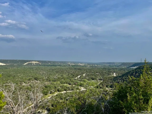 a view of a field with an buildings in back