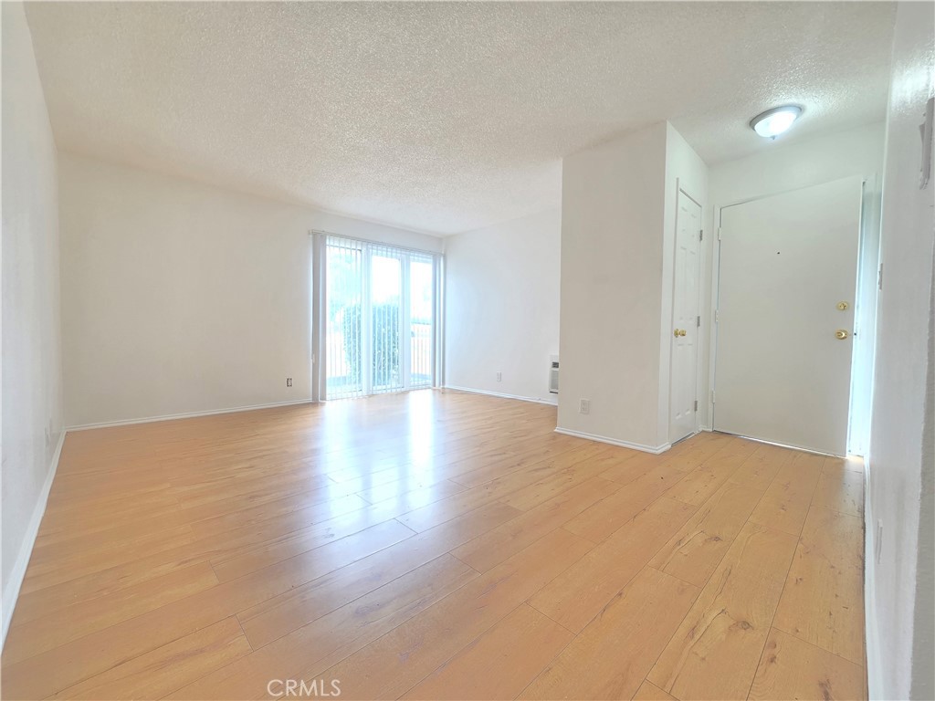 540 East 7th Street, Unit E Upland, CA 91786 - Photo 4 of 9 a view of an empty room with wooden floor and a window