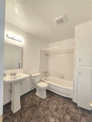 a bathroom with a toilet a sink and bathtub