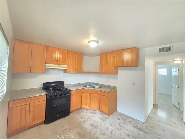 a kitchen with granite countertop a sink and cabinets