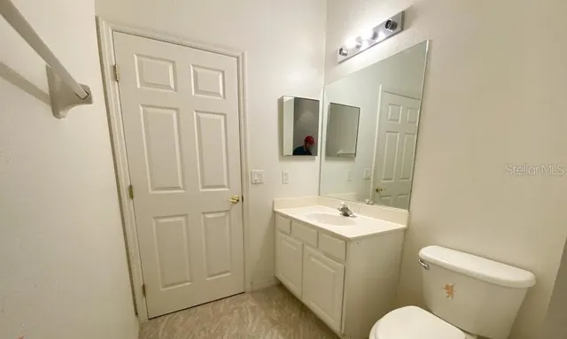 a bathroom with a sink a toilet and mirror