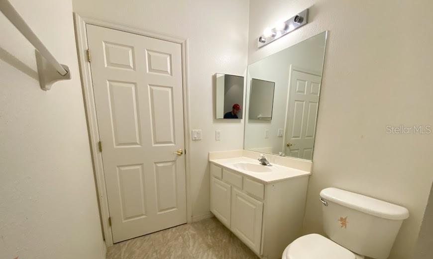 596 Neumann Village Court Ocoee, FL 34761 - Photo 14 of 25 a bathroom with a sink a toilet and mirror