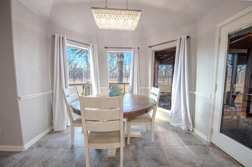 9001 Ravenswood Road Granbury, TX 76049 - Photo 17 of 38 Dining room featuring hanging lights and light stone finish floors