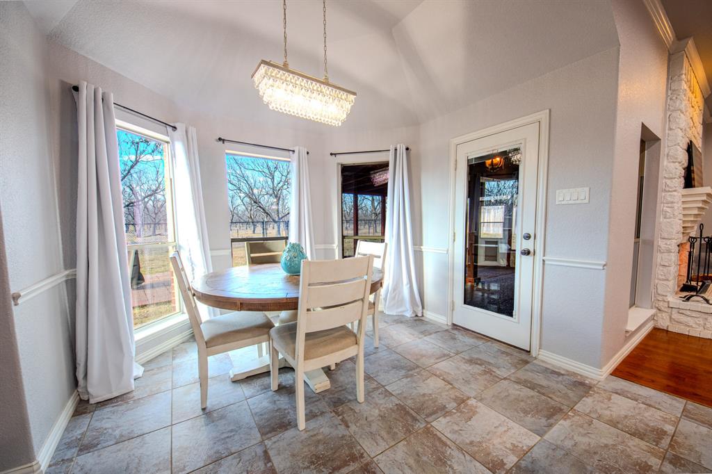 9001 Ravenswood Road Granbury, TX 76049 - Photo 18 of 38 Dining room with vaulted ceiling and a fireplace