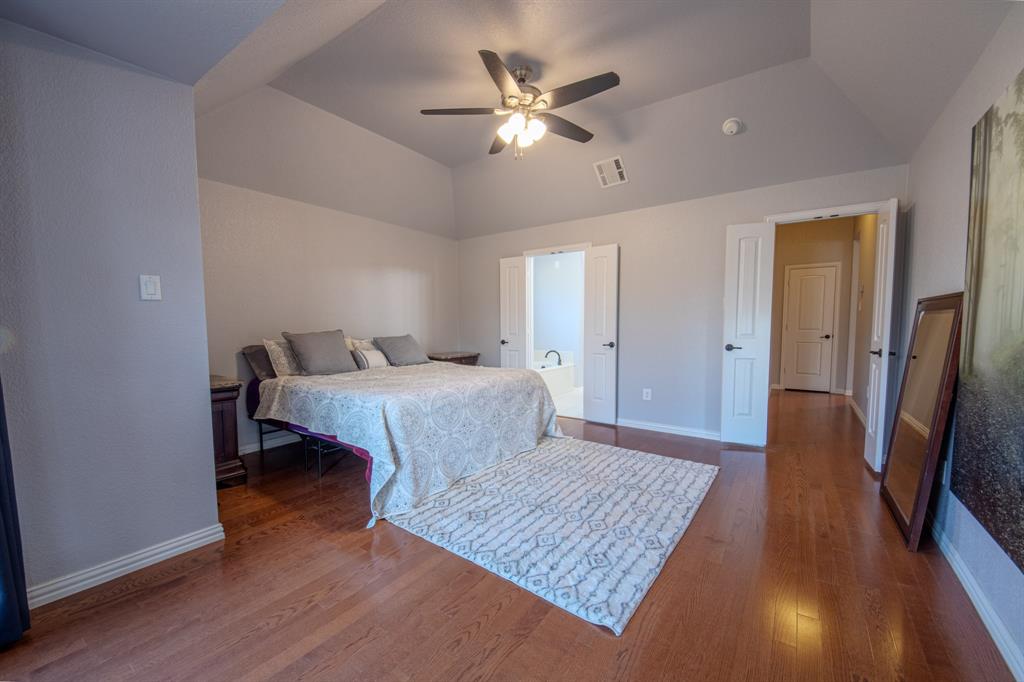 9001 Ravenswood Road Granbury, TX 76049 - Photo 20 of 38 Bedroom with dark wood-style flooring, lofted ceiling, and a ceiling fan