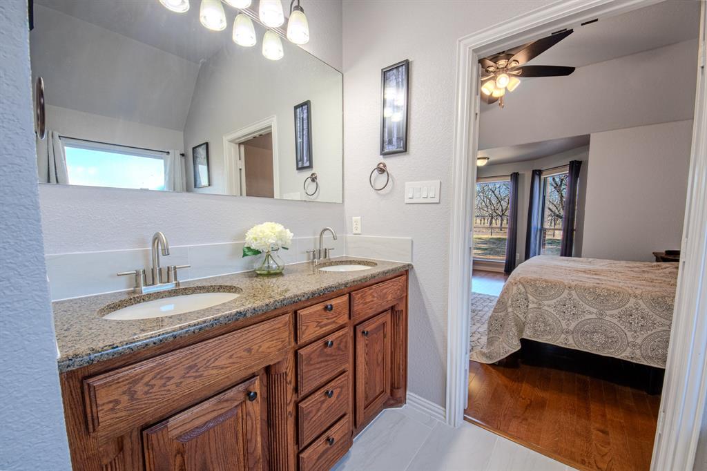 9001 Ravenswood Road Granbury, TX 76049 - Photo 21 of 38 Bathroom with ensuite bath, double vanity, vaulted ceiling, ceiling fan, and a textured wall
