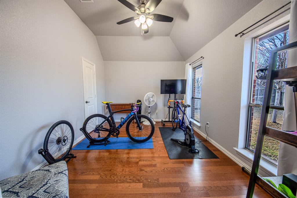 9001 Ravenswood Road Granbury, TX 76049 - Photo 26 of 38 Workout room with a ceiling fan, wood finished floors, and vaulted ceiling