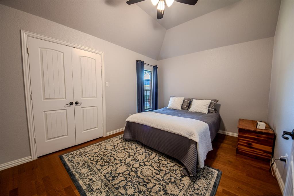 9001 Ravenswood Road Granbury, TX 76049 - Photo 28 of 38 Bedroom featuring lofted ceiling, dark wood-style floors, ceiling fan, and a closet