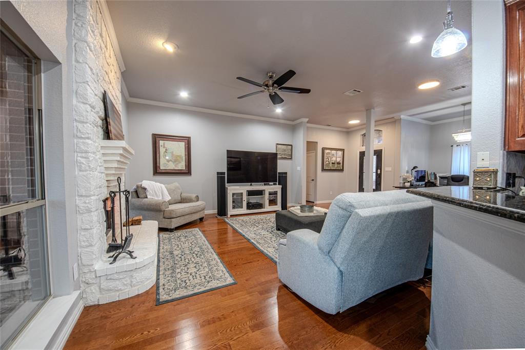9001 Ravenswood Road Granbury, TX 76049 - Photo 10 of 38 Living area featuring a fireplace, ornamental molding, wood-type flooring, ceiling fan, and recessed lighting