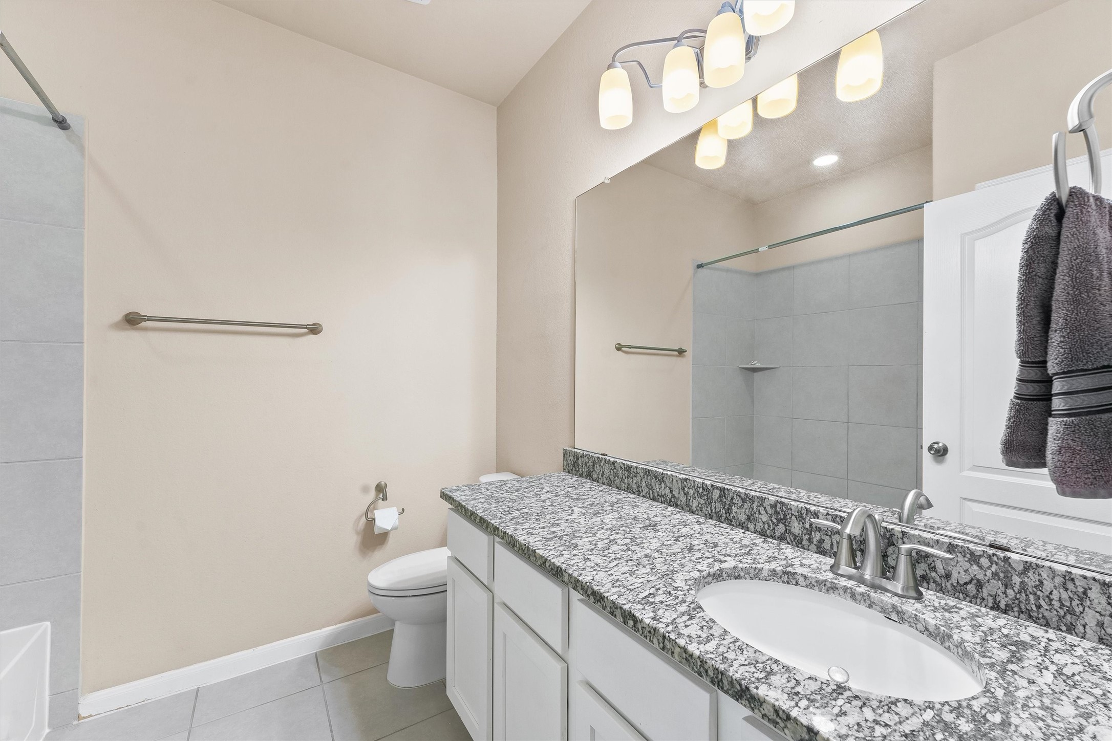 3841 Enchanted Timbers Lane Spring, TX 77386 - Photo 11 of 28 a bathroom with a granite countertop sink a toilet and a large mirror