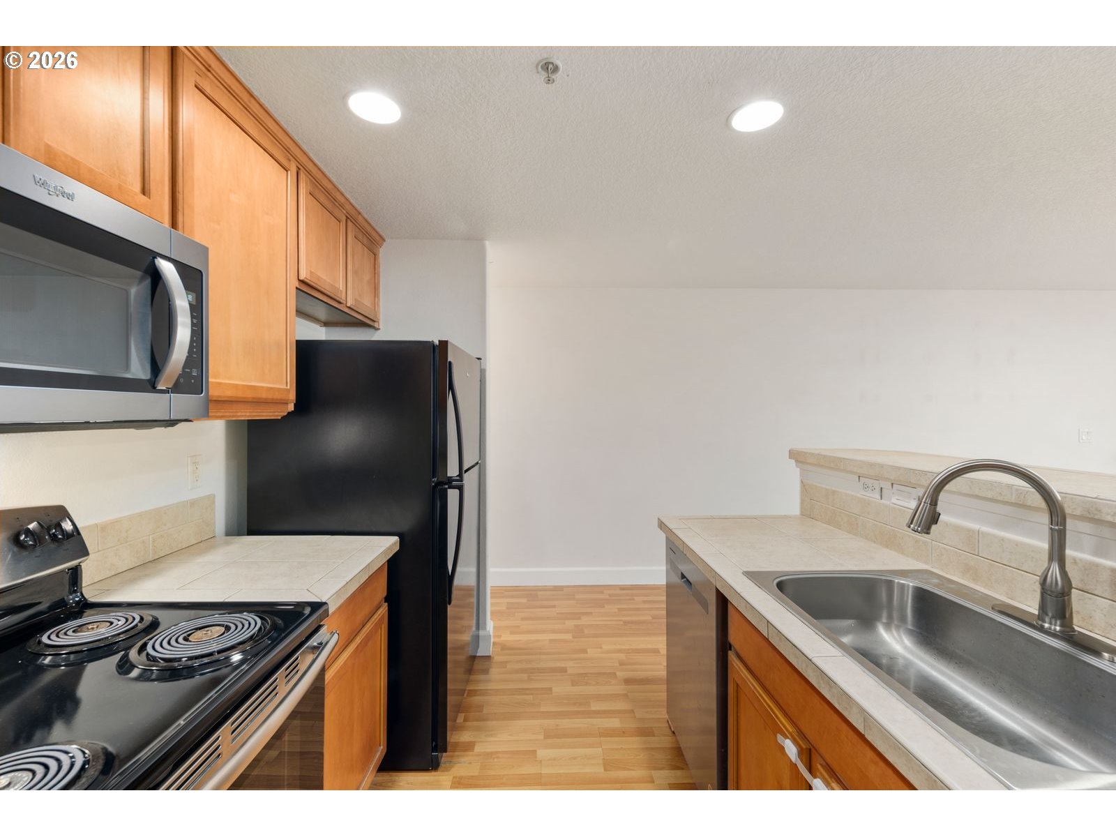 1443 Southeast 8th Avenue Camas, WA 98607 - Photo 14 of 48 a kitchen with stainless steel appliances granite countertop a sink a stove and a refrigerator with wooden floor