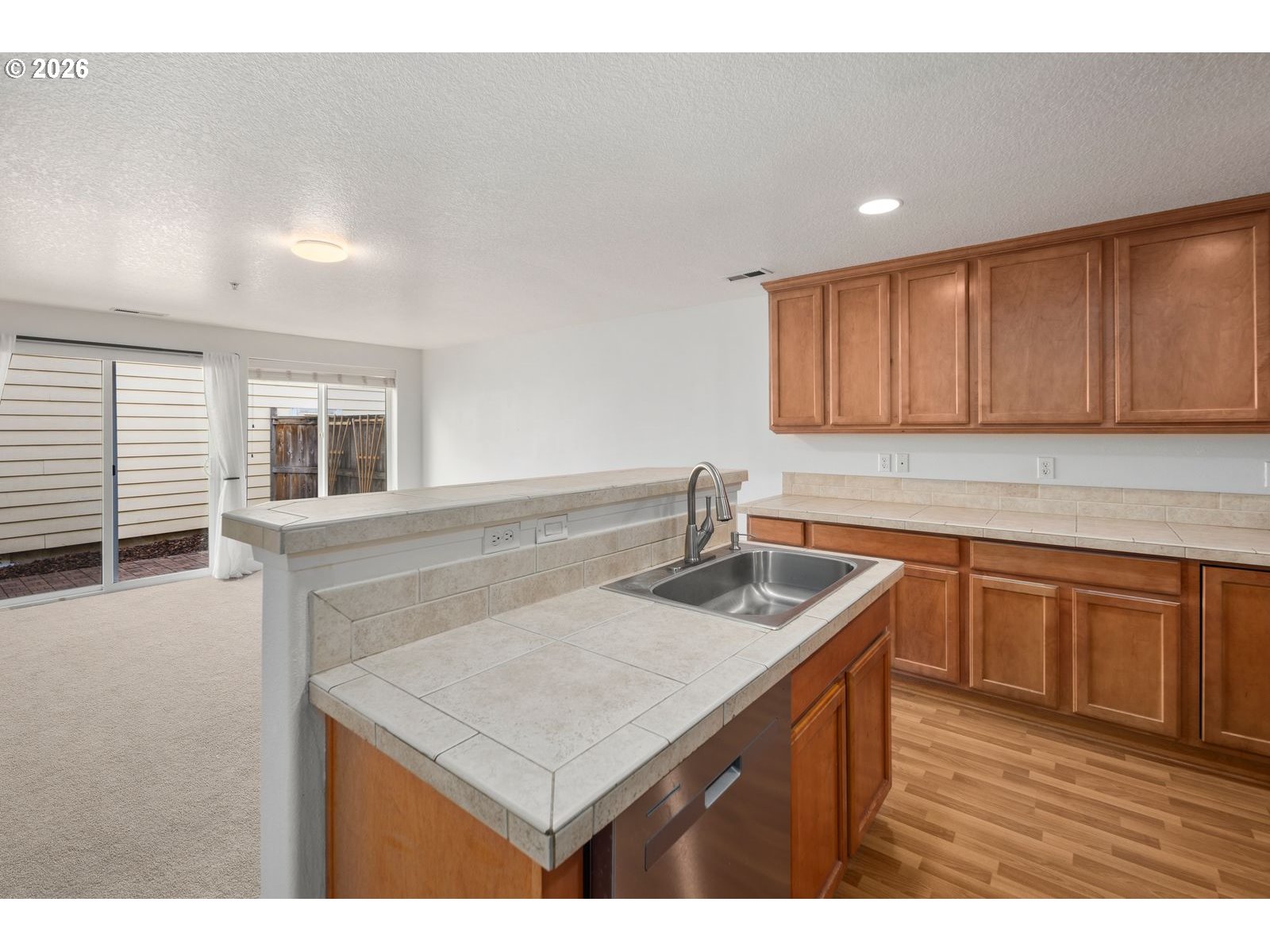 1443 Southeast 8th Avenue Camas, WA 98607 - Photo 9 of 48 a kitchen that has a sink a microwave oven a stove and white cabinets with wooden floor