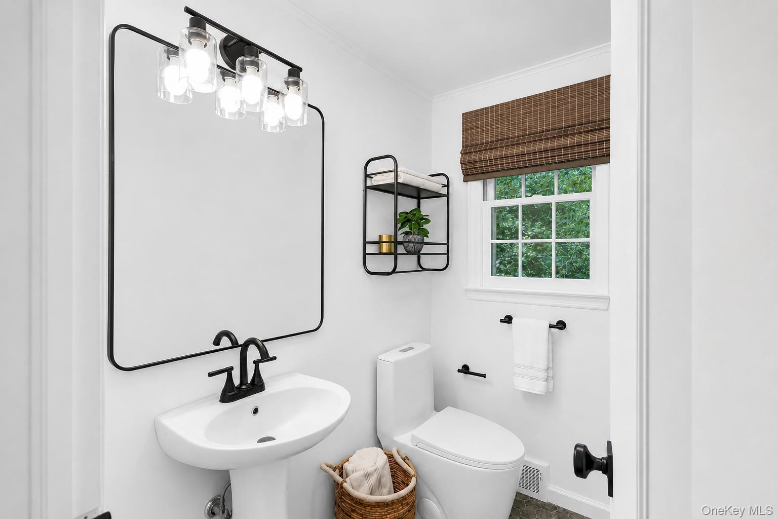 275 Pinewood Road Cutchogue, NY 11935 - Photo 30 of 45 White pedestal sink with matte black faucet, framed mirror, and modern vanity lighting