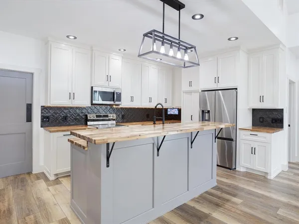 a kitchen with stainless steel appliances granite countertop a stove and cabinets