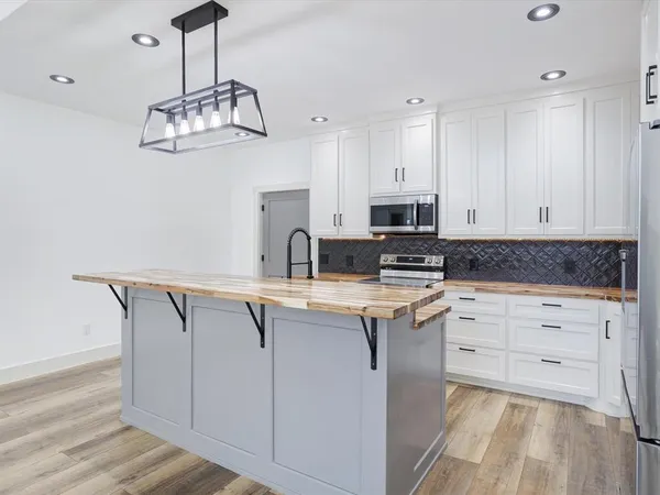 a kitchen with granite countertop a sink stove and refrigerator