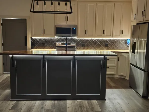 a kitchen with kitchen island granite countertop a stove a sink and a refrigerator